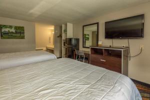 a hotel room with a bed and a flat screen tv at Country Town N' Suites in Gatlinburg