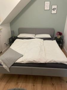 un letto con lenzuola e cuscini bianchi in una camera da letto di Central Hub Kassel City a Kassel