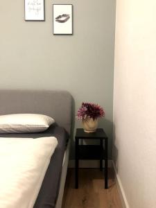 ein Schlafzimmer mit einem Bett und einem Tisch mit einer Pflanze darauf in der Unterkunft Central Hub Kassel City in Kassel