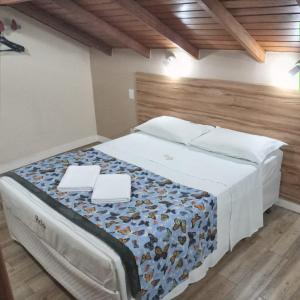 a bedroom with a large bed with two white plates on it at Hotel Hola in Florianópolis