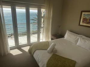 ein Schlafzimmer mit einem Bett mit Blick auf das Meer in der Unterkunft Port Apartment with Sea Views in St Francis Bay