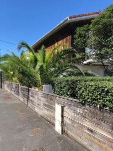a wooden fence in front of a house with plants at A deux pas du port, jolie maison redécorée in La Teste-de-Buch