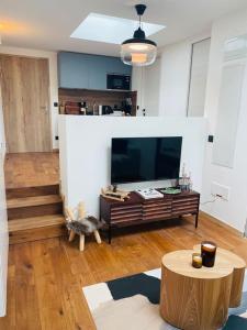 クールシュヴェルにあるDomaine l’Ariondaz 1650, Charmant T2の大きなテレビとテーブルのあるリビングルーム