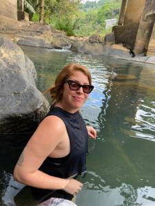 a woman is sitting in a pool of water at Little wood villa Doluwa in Kandy