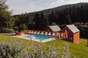 a swimming pool with chairs and a house at Gwiazda Mogielicy basen & balia, sauna in Słopnice +218 photos