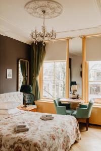 a bedroom with a bed and chairs and a chandelier at Boutique Hotel Museumkwartier in Utrecht