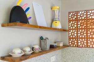 a kitchen shelf with bowls and utensils on it at Buda's Guesthouse in Tanah Lot