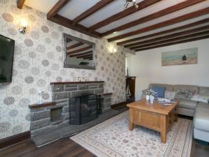a living room with a fireplace and a couch at Pass the Keys Spacious Cottage in central Benllech with parking in Benllech