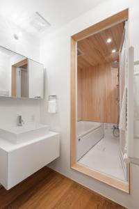 a bathroom with a white sink and a mirror at Hupni Rusutsu in Rusutsu