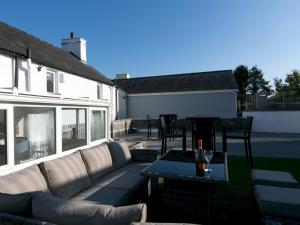 a living room with a couch and a table at Pass the Keys Spacious Cottage in central Benllech with parking in Benllech