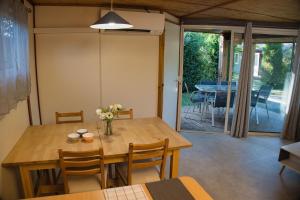 a dining room with a wooden table and chairs at Les chalets de Gaillac in Gaillac