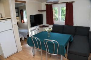 een woonkamer met een blauwe tafel en een bank bij Les chalets de Gaillac in Gaillac