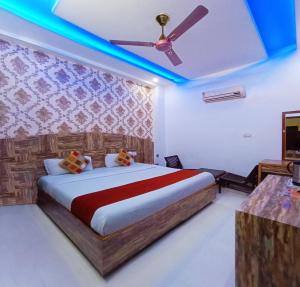 een slaapkamer met een bed, een plafondventilator en een televisie bij Rebirth Hotel in Chandīgarh