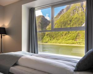 a bedroom with a window with a view of a mountain at Fru Haugans Hotel in Mosjøen
