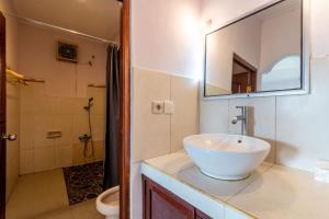 a bathroom with a sink and a toilet and a mirror at Suarsena Ubud in Ubud