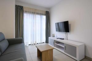 a living room with a couch and a flat screen tv at Canteras Suites in Las Palmas de Gran Canaria