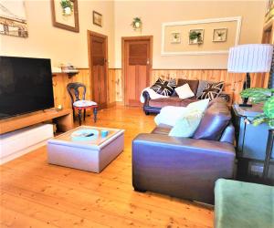un soggiorno con divano e TV a schermo piatto di Whispering Woods House a Maryborough