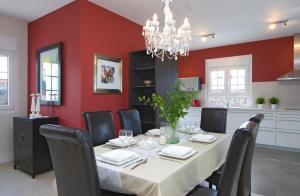 Beautiful Villa Ambar في بويرتو ديل كارمن: غرفة طعام مع طاولة وكراسي وجدران حمراء
