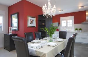 a dining room with a table and chairs and red walls at Beautiful Villa Ambar in Puerto del Carmen