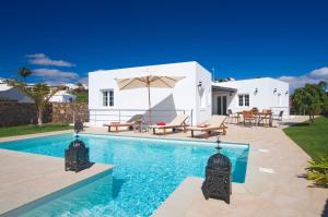 a villa with a swimming pool and a house at Beautiful Villa Ambar in Puerto del Carmen