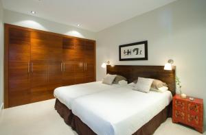 a bedroom with a large bed and wooden cabinets at Beautiful Villa Ambar in Puerto del Carmen +21 photos
