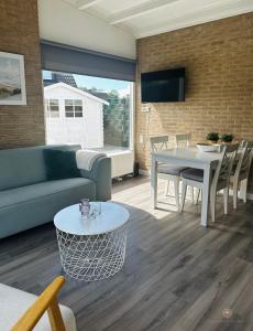 uma sala de estar com um sofá e uma mesa em -Casa Nova- nabij het meer, duinen en restaurants em Noordwijkerhout