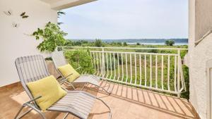 Cette chambre dispose de deux chaises et d'un balcon avec vue sur l'océan. dans l'établissement Apartment Dajana, à Novigrad