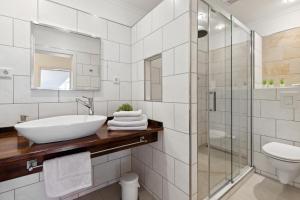 a white bathroom with a sink and a shower at Ferienwohnungen Deidesheim in Deidesheim