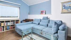 - un salon avec un canapé bleu et une étagère à livres dans l'établissement Apartment Dajana, à Novigrad