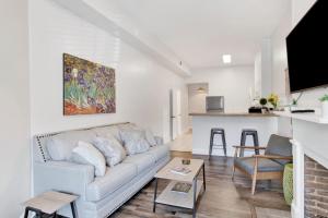 a living room with a couch and a kitchen at Stars on State in the Heart of Downtown in Mobile