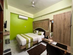 瓦拉纳西Hotel Prabhat的带床和绿墙的卧室