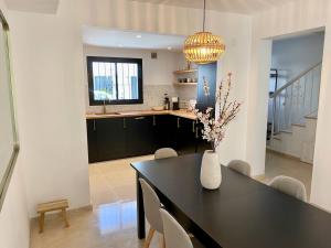 cocina y comedor con mesa y jarrón con flores en Escape to Serenity - 3 Bedroom Townhouse by the Sea!, en Marbella