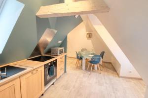 a kitchen with a table and chairs in a attic at le clémenceau in Montbéliard