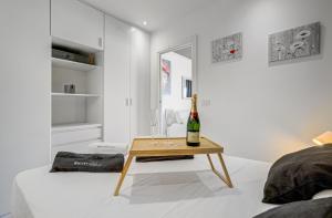 a white bedroom with a bottle of champagne on a bed at Cosy Mareverde FREE WIFI in Adeje