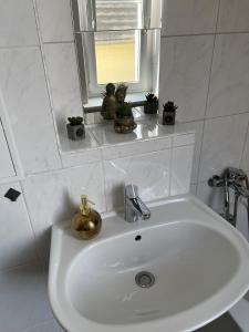 a bathroom sink with potted plants and a window at Apartment 4 - Haus Lausitzring in Annahütte