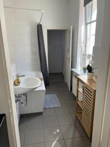 a white bathroom with a sink and a tub at Apartment 4 - Haus Lausitzring in Annahütte