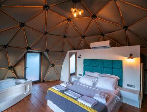 a bedroom with a large bed in a room with a tub at Lusso Glamping Bodrum in Bodrum City