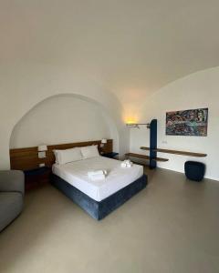 San Marco di Castellabate的住宿－Il Gabbiano Suites，一间卧室配有一张大床和一张沙发