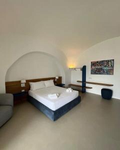 een slaapkamer met een groot bed en een bank bij Il Gabbiano Suites in San Marco di Castellabate