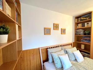a room with a bed with pillows and shelves at Tiétek a HÁZ in Mogyoród
