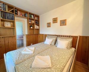 1 dormitorio con 1 cama en una habitación con estanterías en Tiétek a HÁZ, en Mogyoród