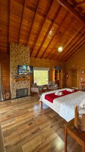 a bedroom with a bed and a fireplace at Chalé Luar da Mantiqueira in Sapucaí-Mirim