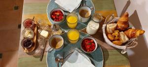 een tafel met een bord ontbijtproducten en -dranken bij La maison WISTERIA in Saint-Pantaléon-les-Vignes
