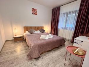 a bedroom with a bed with two towels on it at Agropensiunea Vila Cristina in Niculiţel +85 photos