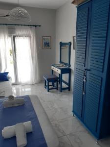 a bedroom with a blue door and a dressing table at Victoria's Blue studios in Siviri
