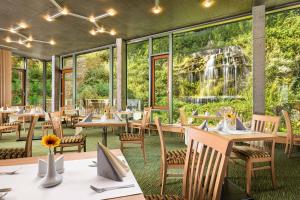 a restaurant with tables and chairs and a waterfall in the background at Hotel Astoria in Jáchymov