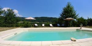 Silhac的住宿－Villa la bastide piscine et jacuzzi，一个带椅子和遮阳伞的游泳池