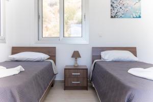 2 Betten in einem Zimmer mit 2 Fenstern in der Unterkunft Villa Aqua Queen in Coral Bay