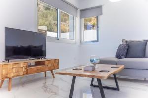 uma sala de estar com uma televisão, um sofá e uma mesa em Villa Aqua Queen em Coral Bay