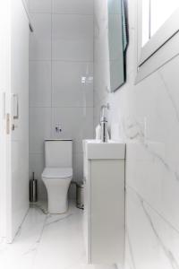 uma casa de banho branca com um WC e um lavatório em Villa Aqua Queen em Coral Bay